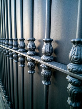 İşlenmiş demir parmaklıklı siyah metal kapı.