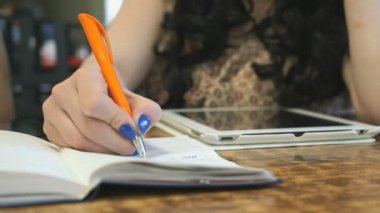 Kız kafede günlüğüne yazar. Portre