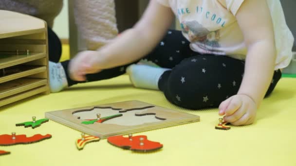 Dziecko działa z zagadkami, siedząc na podłodze — Wideo stockowe