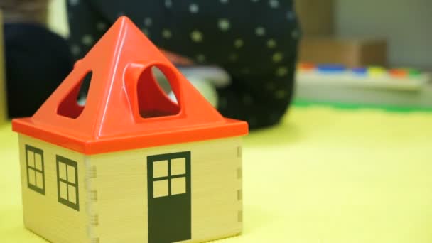 Casa giocattolo per bambini con tetto rosso sul pavimento — Video Stock