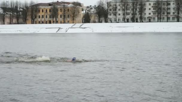 Зимой человек плавает в холодной речной воде. Морж — стоковое видео