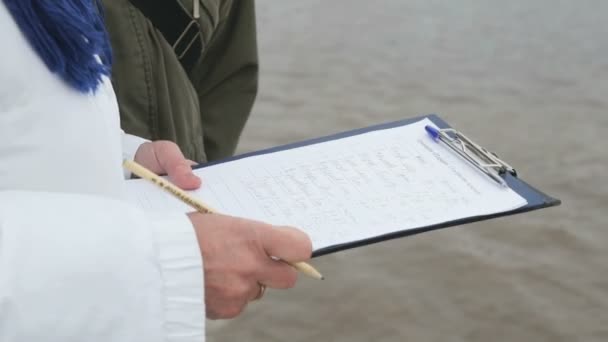 Trainer schrijft de resultaten van het zwemmen van de mens — Stockvideo