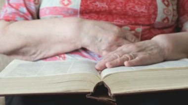 Elinde bir kitap tutan yaşlı kadın