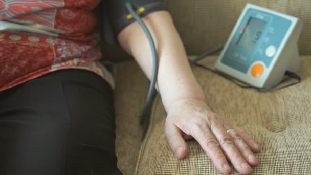 Stara kobieta, sama mierzy ciśnienie — Wideo stockowe