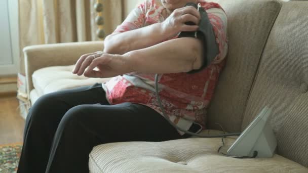Стара жінка вимірює собі кров'яний тиск — стокове відео