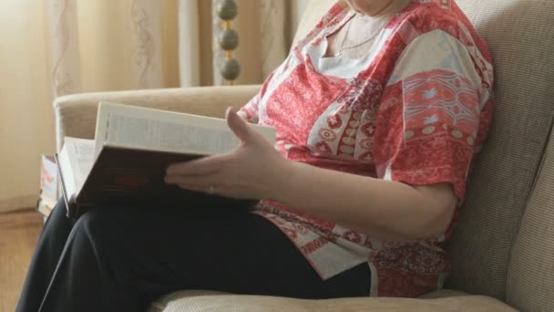 Mulher velha lendo as páginas do livro grosso — Vídeo de Stock