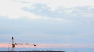 İşçi yönetir inşaat bir gündoğumu vinç