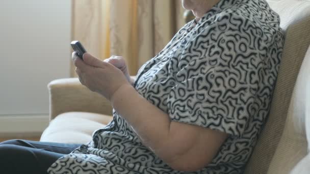 Стара жінка набирає номер на мобільному телефоні — стокове відео