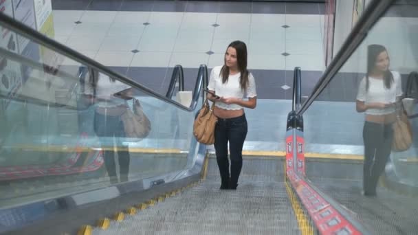 Elegante chica de moda paseos en una escalera mecánica — Vídeos de Stock