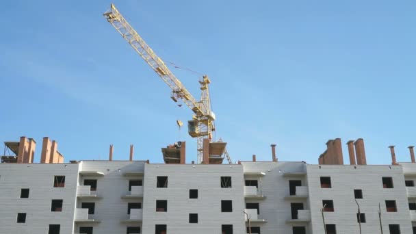 Grue de construction travaillant sur un immeuble d'habitation — Video