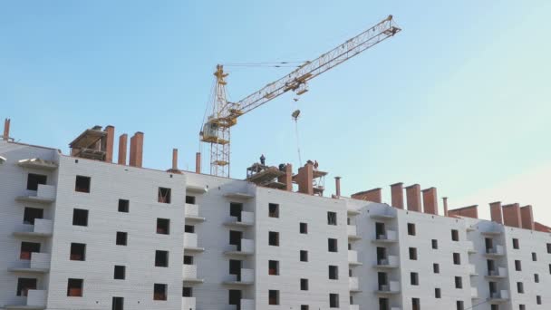 Bir apartmanın üzerinde çalışan inşaat vinç — Stok video