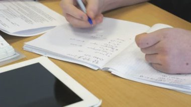 Kız bir okul matematik defterde yazar