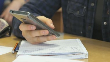 Masada oturan ve bir cep telefonu tutan kız