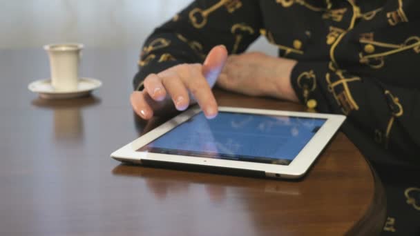 Žena pracuje na digitálním tabletu, pití kávy — Stock video