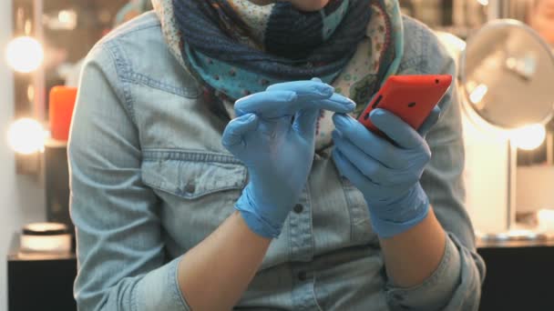 Мастер держит телефон красным в синих резиновых перчатках — стоковое видео