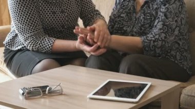 Kadın yaşlı bir kadının buruşuk bir el tutar