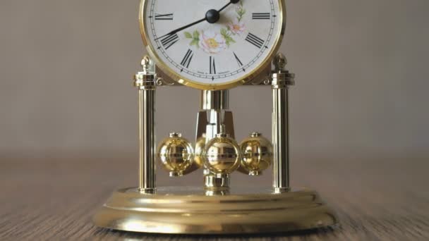 Clock with a pendulum in a form of rotating balls — Stock Video