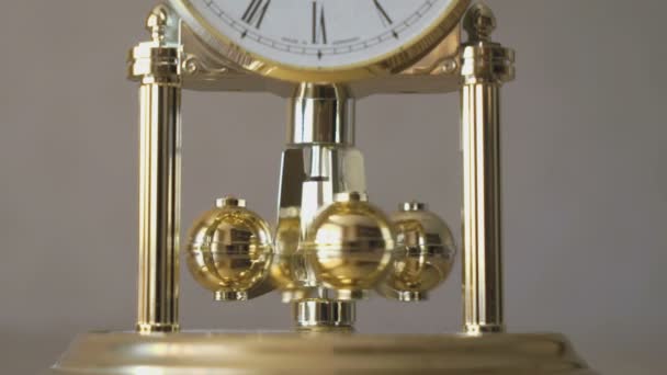 Clock with a pendulum in a form of rotating balls — Stock Video