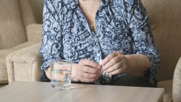 Stará žena vezme prášek a pije vodu — Stock video