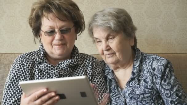 Deux femmes regardant des photos sur une tablette numérique — Video