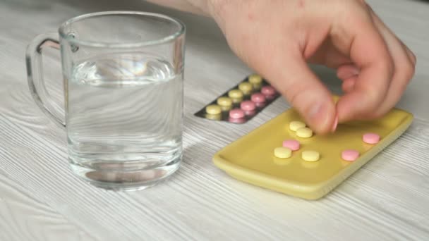 Mans hand neemt de pillen van een gele container — Stockvideo