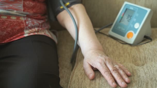 Женщина измеряет артериальное давление тонометром — стоковое видео