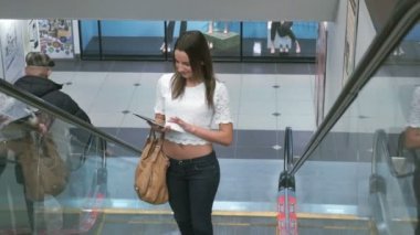 Kız alışveriş merkezinde yürüyen merdiven tarafından sürüş