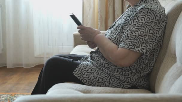 La mujer enciende el televisor con el mando a distancia — Vídeo de stock