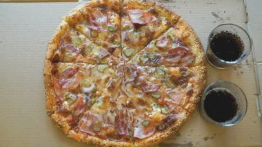 Et pizza ve kola iki bardak bir masaya vardır