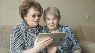 İki kadın resimleri dijital tablet izlerken