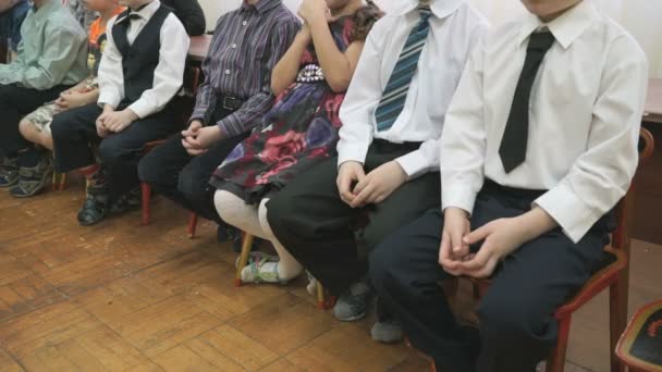 Children sit on chairs at a kindergarten — Stock Video