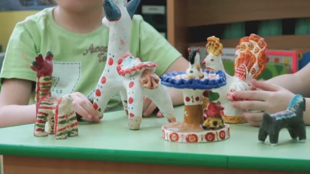 Kinder spielen in einer dekorierten Bastelei aus Ton — Stockvideo