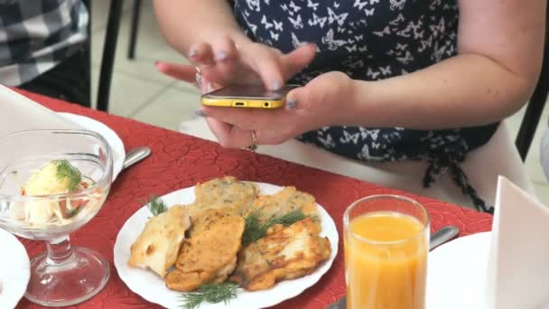 Una chica sosteniendo un teléfono móvil en sus manos — Vídeos de Stock