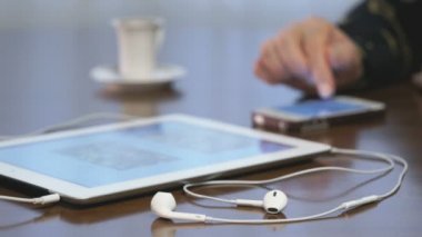 Belgili tanımlık smartphone ve bir tablet üzerinde müzik arayan kadın