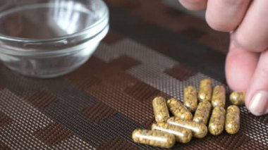 Kadının el kapsül hap kapsayıcısında koyar.