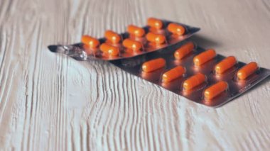 Turuncu kapsül hap üzerinde beyaz bir tablo sonbahar