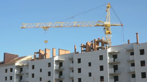 Construcción de casas de apartamentos. La grúa funciona — Vídeos de Stock