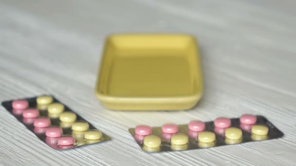 Hand faltet Tabletten in Behälter auf einem Tisch — Stockvideo