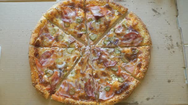 Mãos tirando pedaços de pizza de uma caixa de papelão — Vídeo de Stock