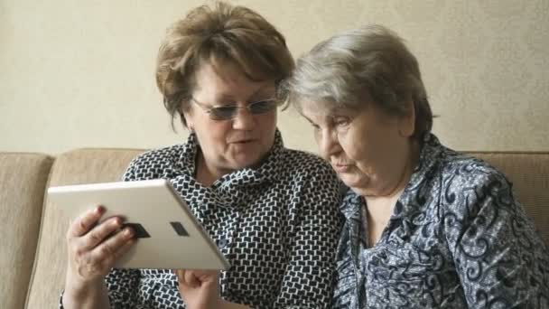 Twee vrouwen kijken naar foto's op een digitale tablet — Stockvideo