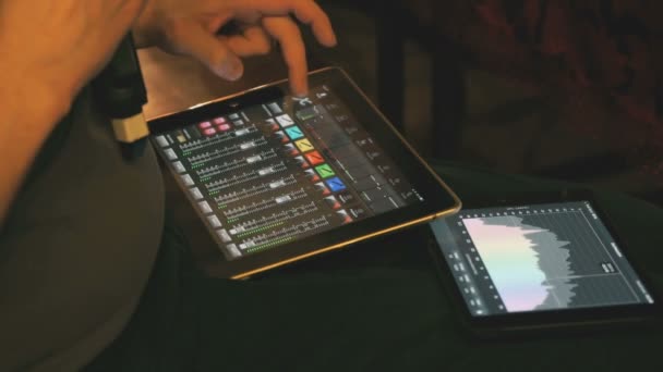 Man adjusts sound equipment using a digital tablet — Stock Video