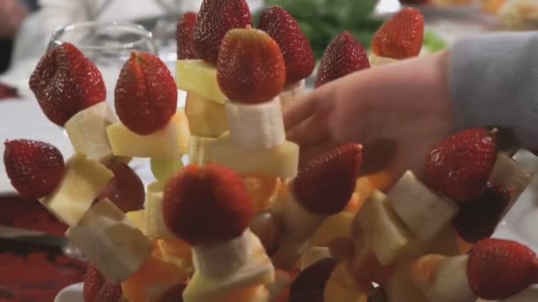 Hand nimmt einen Stock mit Früchten aus Obstkorb — Stockvideo