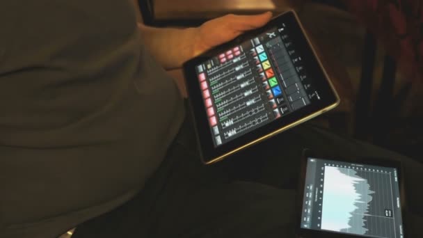 Homem ajusta equipamentos de som usando um tablet digital — Vídeo de Stock