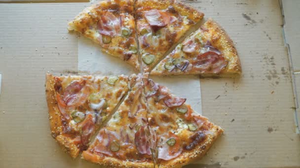Mains prenant des morceaux de pizza dans une boîte en carton 