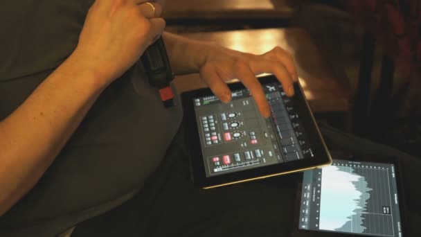 Man adjusts sound equipment using a digital tablet — Stock Video