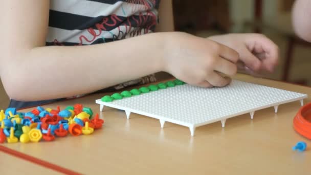 Klein kind speelt een intellectueel spel aan een tafel — Stockvideo