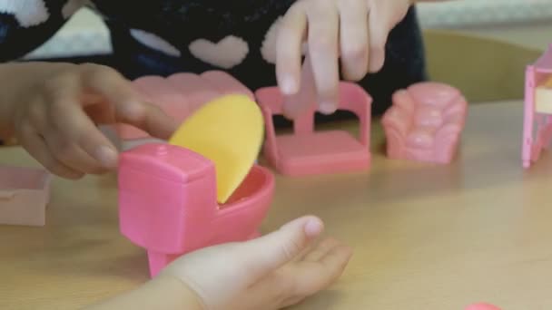 Дети играют в детскую мебель за столом — стоковое видео