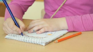 Çocuk resimleri defterini çizer.