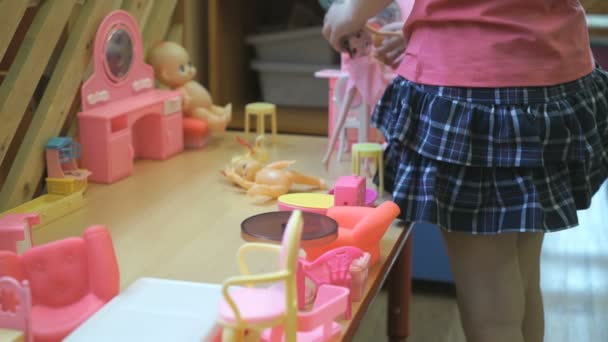 Meisje speelt childrens meubilair aan tafel — Stockvideo