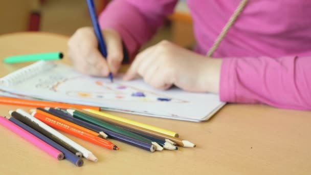 Criança desenha as imagens no caderno — Vídeo de Stock